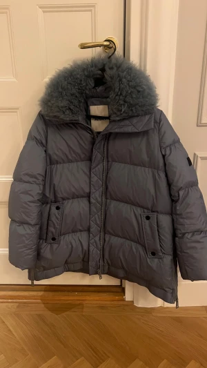 Vinterjacka Yves Salomon - Säljer en grå blå pufferjacka från Yves Salomon, modell YS Army. Använd endast 1 gång! Nypris ca 12 000kr.