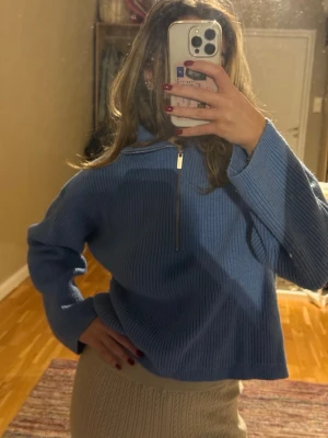 Blå stickad half zip tröja H&M - Mysig blå stickad tröja från H&M med half zip framtill och bred krage. Ribbad struktur som ger en snygg vibe.