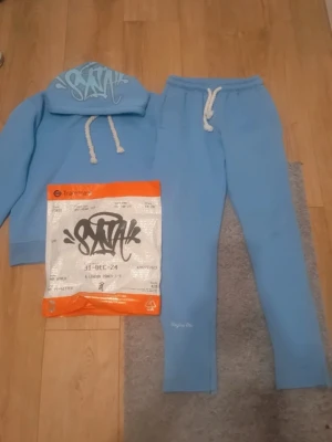 Blå mjukisbyxor Forgive Me - Säljer ett par ljusblå mjukisbyxor från Forgive Me med broderad logga vid benslutet. Byxorna har snörning i midjan och är gjorda i mjukt fleece-material. Perfekta för chill och häng, med normal passform och elastisk midja.