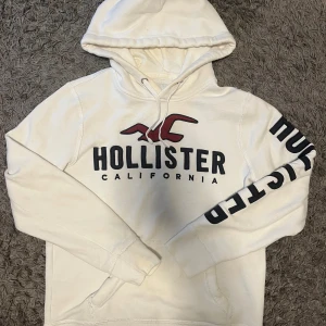 Hollister Hoodie - Märke: Hollister Skick: 8/10 Färg: vit med röda och svarta detaljer Storlek: S  Hör av dig vid andra funderingar eller frågor! Priset kan ändras vid snabbt köp!