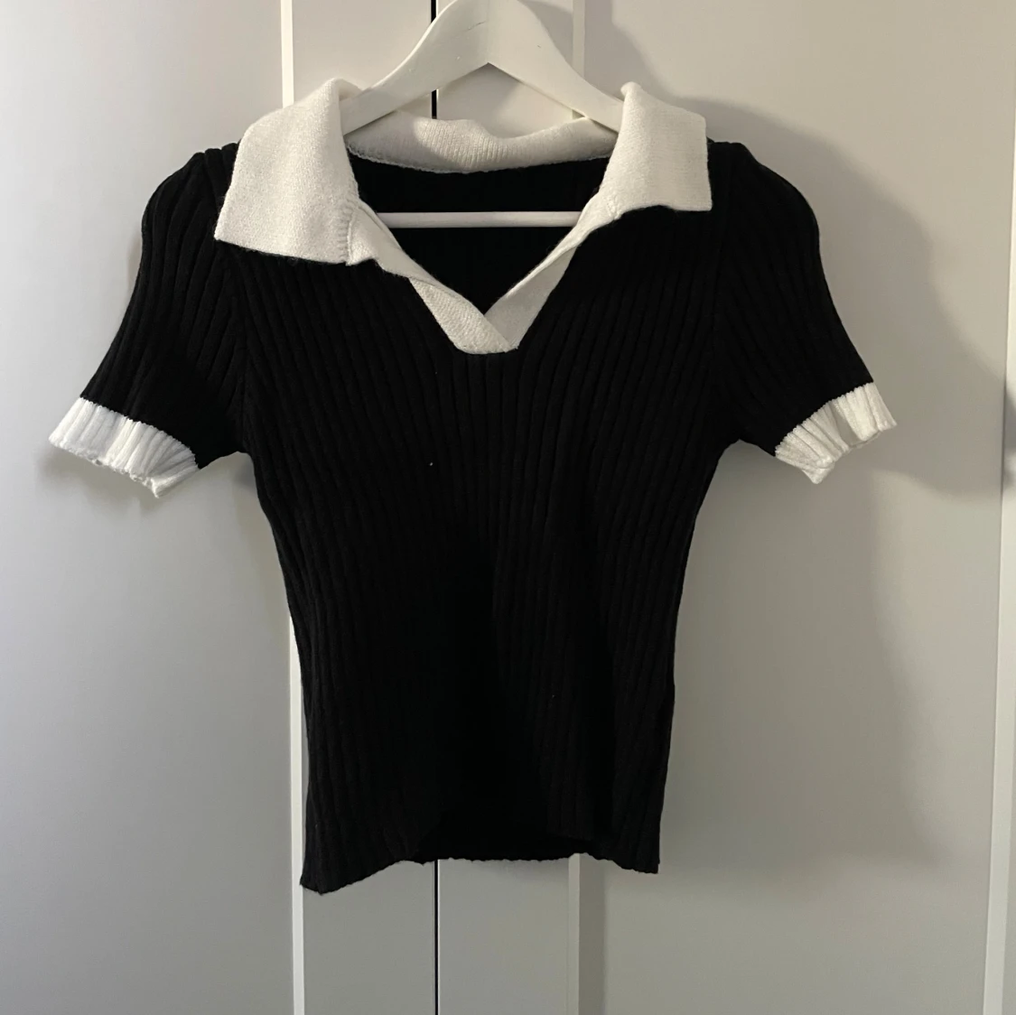 Svart ribbad topp med vit krage