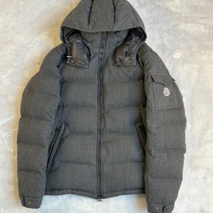 Moncler montgenevre grå - Moncler montgenevre grå i storlek 4. Sitter som en M-L. Några enstaka klassiska montgenevre defekter men inget som syns vid användning. Självklart äkta! DM vid intresse!