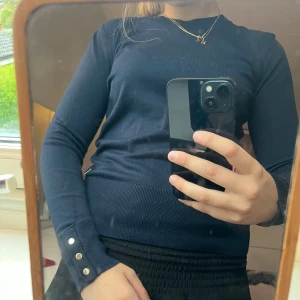 Mörkblå stickad tröja med knappar - Mörklblå långärmad tröja med guld knappar som detaljer.💕