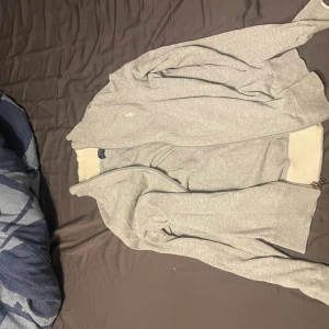 Grå kofta från Polo Ralph Lauren - Säljer en stilren grå kofta från Polo Ralph Lauren skön till vintern som kommer finns en defekt o de är hålet som syns på en av bilderna inget man märker av. PRIS ÄR EJ HUGGET I STEN