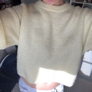 Ljusgul croppad stickad tröja - Supermysig ljusgul stickad tröja med croppad passform och rund hals. Tröjan har lite bredare ärmar och är perfekt för dig som gillar en chill och trendig look. Passar dig som vill ha något mjukt och fluffigt i garderoben. Köpt på Gina i somras för 400 tror jag, säljes för 300 💞