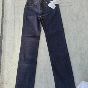 Mörkblå jeans från ONLY, Alicia 27/32 - Mörkblå jeans från ONLY, modell Alicia Straight med regular waist. Klassisk femficksdesign, raka ben och snygga kontrastsömmar. Tillverkade i stretchig denim för skön passform. Perfekta för dig som gillar en tidlös look.