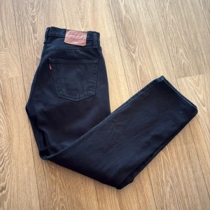  Levi's 501 jeans - Svarta Levi's 501 jeans med klassisk rak passform och femficksdesign. aldrig använda bara testat dom. Jeansen har läderpatch bak i midjan och den ikoniska röda Levi's-taggen på bakfickan. Tillverkade i robust denim med knappgylf och snyggt minimalistiskt uttryck.