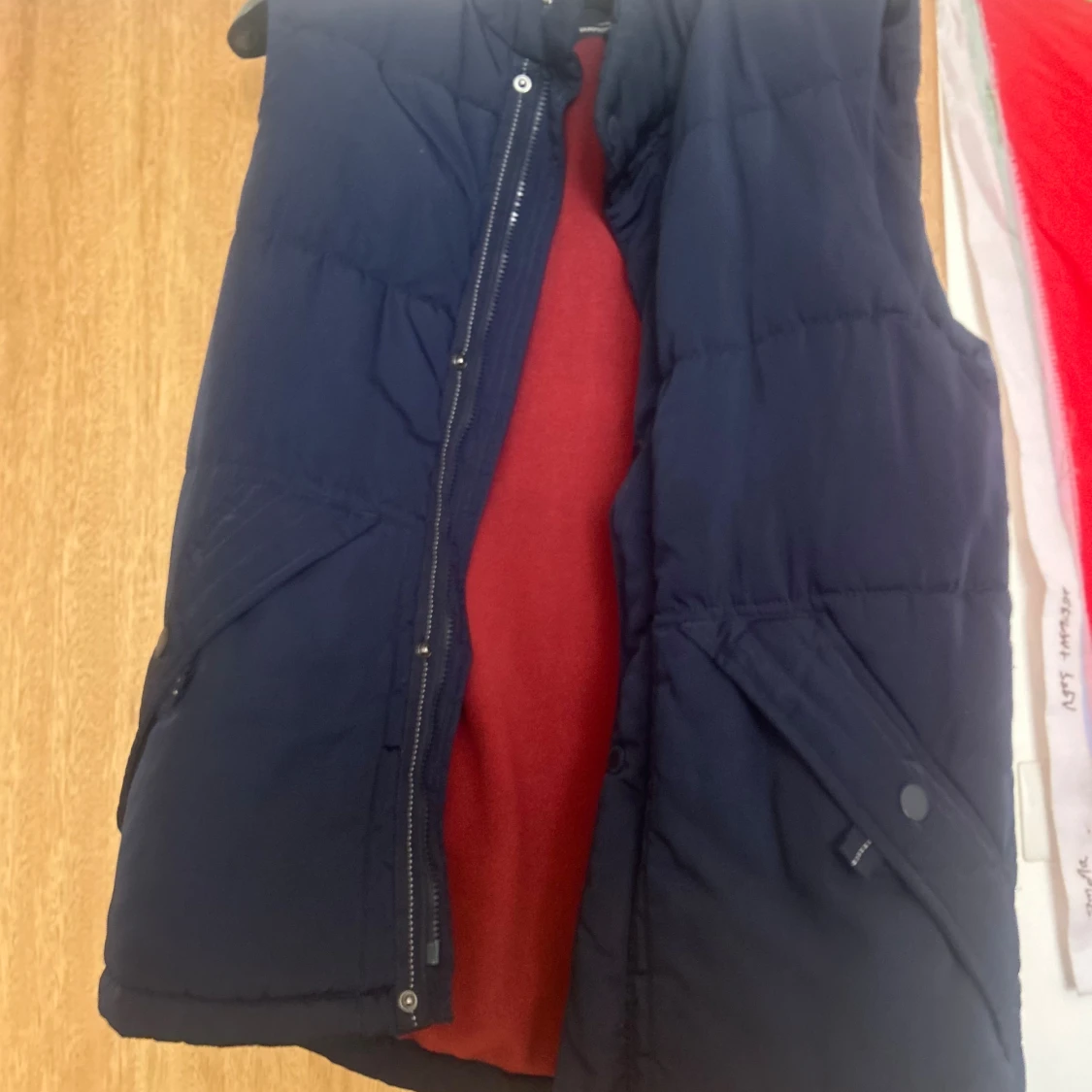 Mörkblå dunväst med röd fleecefoder