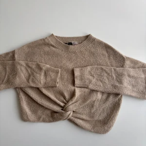 Stickad tröja med knut framtill - Superfin beige stickad tröja från Gina Tricot med lång ärm och snygg knutdetalj framtill. Tröjan har en rund halsringning. Enkel att styla med både jeans och kjol.