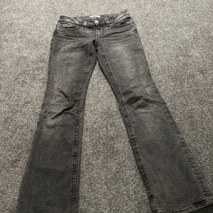 Svarta bootcut jeans från Perfect Jeans - Snygga svarta bootcut jeans från Perfect Jeans i storlek 36. Jeansen har klassisk femficksdesign, coola bakfickor med lock och silverfärgade knappar. Materialet är jeans med en lätt tvättad look och normal passform. Perfekta för dig som gillar en tidlös stil.