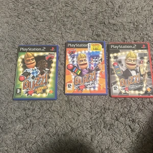 Buzz! The Sports Quiz, Buzz! The Pop Quiz, Buzz! The Hollywood Quiz (PlayStation 2) - Samling med tre Buzz!-spel till PlayStation 2: The Sports Quiz, The Pop Quiz och The Hollywood Quiz. Alla fodral och skivor är med, i gott skick med mindre bruksspår. Perfekt för party och frågesport med vänner!