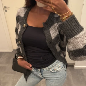 Randig cardigan med knappar - Mysig grå kofta med randigt mönster. Koftan har stora knappar framtill, ribbade muddar och är stickad i ett mjukt material 🎀