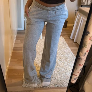Grå mjukisbyxor med raka ben - Ljusgrå mjukisbyxor med raka, lite vidare ben och resår i midjan. Från BikBok. Byxorna har fickor på sidorna och är väldigt mjuka och mysiga. Långa på mig som är 158cm. Använda endast 1 gång. 