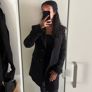 Svart kappa med knappar - Stilren svart kappa med klassisk krage. Kappan är från Mango och är i storlek xxs men passar mig som har storlek xs. Nypris 999kr