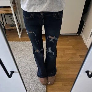 Jeans med hål  - Säljer mina skit snygga och super lågmidjade jeans med egengjorda hål! Har även sytt dom bootcut själv! Midjemåttet är 35cm och innerbenslängden är 72cm, säljer pga att jag inte använder dom🥰