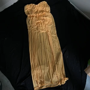 Gul axelbandslös långklänning NLY ONE - Säljer en snygg gul axelbandslös långklänning från NLY ONE. Klänningen har en rak och luftig passform med resår upptill för att sitta på plats. Perfekt för sommarens alla tillfällen när du vill sticka ut i en fräsch färg.