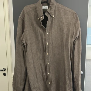 Brun skjorta från Stenströms i bomull - Snygg brun skjorta från Stenströms i fitted body-modell. Tillverkad i tvåfaldig super cotton som känns mjuk och lyxig. Klassisk krage, långa ärmar och knäppning framtill. Perfekt för dig som gillar stilrena och tidlösa plagg. Inte använd så mycket 