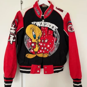 Tweety collegejacka från Lot29 - College bomberjacka från Lot29 med stor Tweety-tryck både fram och bak samt strasstenar. Jackan har broderade detaljer, tryckknappar och ribbade muddar. 