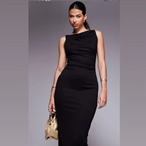 Svart långklänning med slits - Nyköpt klänning från ASOS, helt oanvänd med lappar som tillkom kvar. Anledning till att jag säljer är för att jag beställde flera klänningar till en förlovning och glömde att returnera varorna. Nypris: 599kr