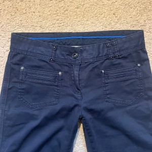 Mörkblå bootcut byxor med broderi - Snygga mörkblå byxor (liknande chinos) med bootcut passform och broderade detaljer på bakfickorna. Skriv för fler bilder!