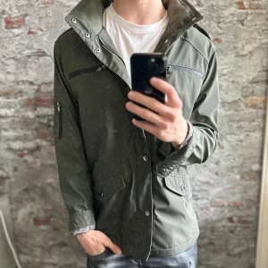 Field Jacket - Riley - Mycket fint skick, inga defekter. Storlek 52/L passar dig som är mellan 180-190cm ungefär. Nypris ca 2000kr. Modellen är 185 cm, 79 kg. Passar bra nu till vintern. Skriv för mer information!🤝