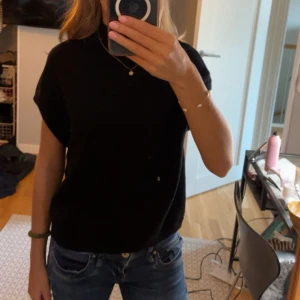 Svart stickad polotröja utan ärm - Stickad topp från Kappahl i storlek S, inte mycket använd och har inga defekter 