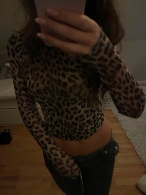 Leopardmönstrad mesh topp Gina Tricot XS - Säljer en långärmad mesh topp från Gina Tricot i storlek XS. Toppen har ett snyggt leopardmönster i beige och svart, är figurnära och har en croppad passform. Toppen är helt ny och aldrig använd.