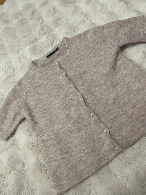 stickad kofta med pärlknappar - Mysig stickad kofta från 157 i storlek XS. Koftan har rund hals, långa ärmar och pärlknappar framtill som ger en extra touch. Perfekt för Materialet är mjukt och värmande. Har använt ca 1 gång som ny! Färgen är lite ljusare än bilden.