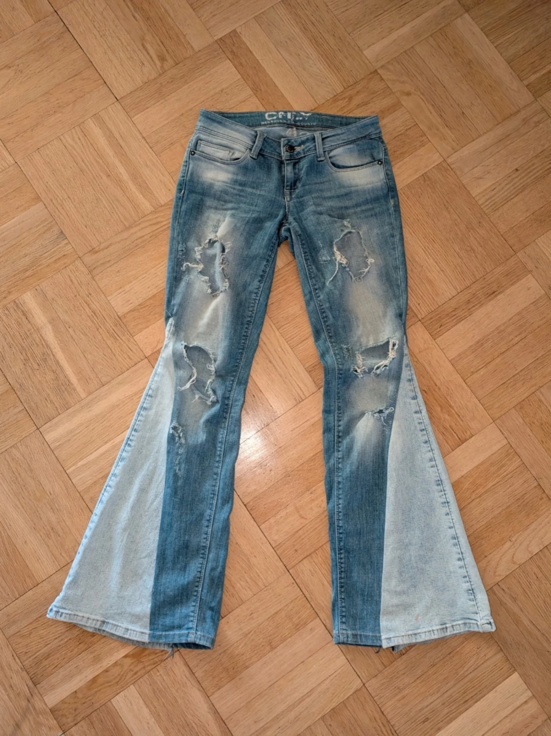 Blå bootcut jeans med slitningar