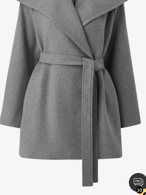 Grå omlott kappa med bälte - Snygg grå kappa med bred krage och omlott-design. Jackan har ett matchande bälte i midjan och är långärmad. Materialet är mjukt och känns som ull, perfekt för kyliga dagar. Enkel och stilren look som funkar till många outfits.