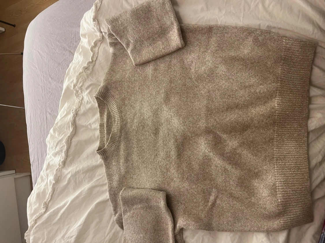 Beige stickad tröja med ribbade muddar