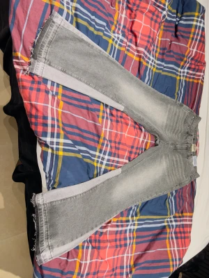 Grå bootcut jeans från Gallery Dept. - Säljer ett par grå jeans från Gallery Dept. med bootcut-snitt och råa, fransiga benslut. Jeansen har en ljusgrå tvätt och klassiska fem fickor. Materialet är jeans och de har en cool, bred passform som sticker ut. Passar inte mig, Skriv till mig för frågor! 