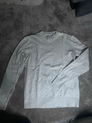 Vit/beige tröja från These Glory Days - Säljer en stilren vit/beige tröja från These Glory Days i storlek small. Tröjan har rund hals, långa ärmar och ribbade muddar vid ärmslut och nederkant. Perfekt för dig som gillar enkel och clean look. Materialet är mjukt och känns skönt mot huden.