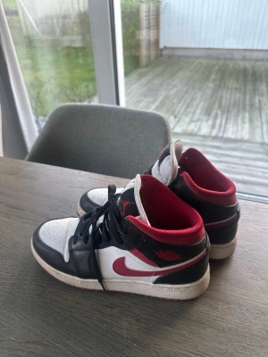 Nike Air Jordan 1 svart/röd/vit - Säljer ett par Nike Air Jordan 1 sneakers i svart, rött och vitt. Storlek 38 använd några gånger väldigt bra skick.
