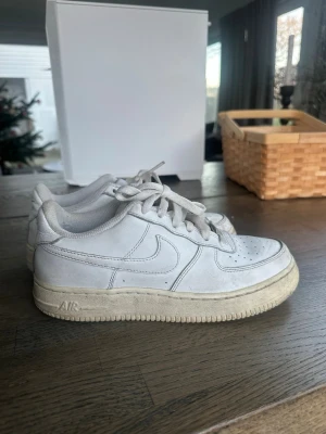Nike Air Force 1 vita sneakers - Klassiska Nike Air Force 1 sneakers i helvitt,. Storlek 38. Har litet hål där inne ovanför hälen men inget man känner av när man väl ha på sig skorna. Pris kan diskuteras. 