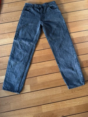 Svarta raka jeans 30/32 - Säljer ett par svarta jeans med rak passform och klassisk femficksdesign. Jeansen har bälteshällor och knappgylf. Perfekta för dig som gillar en enkel och tidlös look. Storlek 30/32.
