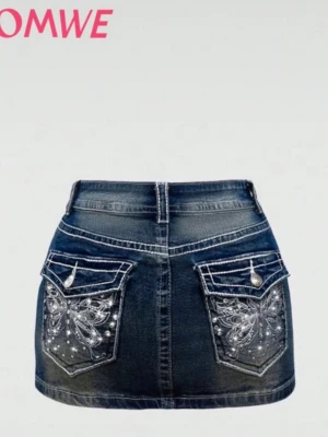 Blå jeanskjol med broderade fjärilar - Säljer en blå jeanskjol från ROMWE med hög stretch. Kjolen är kort och har snygga broderade fjärilar med pärlor på bakfickorna. Klassisk femficksmodell med knapp och dragkedja framtill. Perfekt för dig som gillar detaljer och denim.