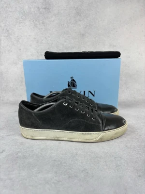 Lanvin DBB1 cap toe sneaker - – Condition: 8/10 - dirty  - Size: 44/UK10  – What is included: Only the sneakers  – Retail price: 5500 + SEK  Please note that Lanvins fit big and our recommendation is to go one size down