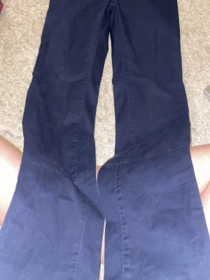 Midrise Mörkblå chinos från Boomerang bootcut  - Snygga mörkblå chinos från Boomerang i storlek 38. Byxorna har klassisk rak passform och är gjorda i mjuk bomull. Perfekta för dig som gillar stilrena och bekväma byxor med dragkedja och knapp framtill.