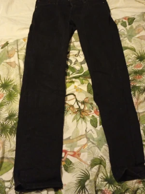 Jeans från Jack & Jones - Svarta jeans från Jack & Jones med klassisk femficksdesign och dragkedja. Jeansen har en rak passform och är tillverkade i slitstarkt bomullsmaterial. Perfekt för dig som gillar stilrena och enkla jeans med snygg look. Pris kan sänkas vid en villig affär 