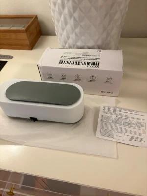 WX0003 Ultrasonic Cleaner - Effektiv ultraljudsrengörare för smycken, rakapparater, makeupborstar och små hushållsartiklar. Högfrekvent vibration ger snabb och grundlig rengöring. Produkten är i nyskick med originalförpackning och manual. Perfekt för daglig användning och enkel att hantera.