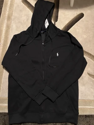 Svart Polo Ralph Lauren hoodie - Varm och skön. Luva med fickor och väldigt stilig