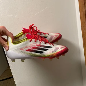 Adidas F50 Elite AG Fotbollsskor (konstgräs) - Jag säljer ett par storlek 42 2/3 Adidas F50 Elites AG (konstgräs). Anledningen för att jag säljer dom är pga att de inte riktigt passar min fottyp. Dom köptes 28 September och har bara används ett fåtal gånger (kvitto finns). Har haft ett hälskydd där bak på vänsterfoten vilket medfört att det kan vara lite klibbit där bak. ORDINARIE PRIS 3099 KR.