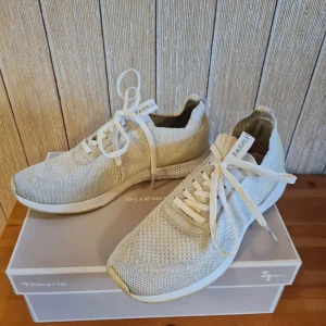 Vita sneakers från Tamaris strl 39 - Snygga vita sneakers från Tamaris i storlek 39 med stickad ovandel i syntet och klassisk snörning.