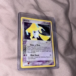 Jirachi - Snygg och samlarvänlig Pokémon-kort med Jirachi! Perfekt för dig som älskar Pokémon och vill utöka din samling med ett unikt kort från 2004. Kortet är i skyddande plastfodral och har coola attacker som 'Make a Wish' och 'Mind Bend'.