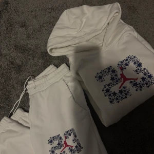 Vitt sett från Jordan med tryck - Säljer en vit hoodie från Jordan med stort 23-tryck i blått och svart med stjärnmönster och röd Jumpman-logga på bröstet. Hoodien har huva, magficka och långa ärmar. Materialet är mjukt och fleecefodrat, perfekt för chill eller sport. 