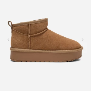 Bruna mockaboots med plattform - Snygga bruna boots i mocka med plattformsula och rund tå. Skorna har en låg siluett och synliga sömmar som ger en cool och avslappnad vibe. Perfekta för höst och vinter när du vill hålla stilen och värmen.