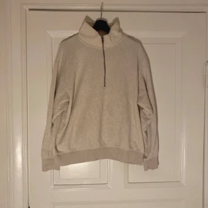 Beige half zip sweatshirt - Säljer en beige sweatshirt med half zip och hög krage. Tröjan har en loose passform och långa ärmar med ribbade muddar. Perfekt för chill dagar och enkel att matcha med jeans eller mjukisbyxor.