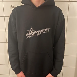 Saint Laurent hoodie - Riktigt fet och eftertraktad hoodie med saint laurent loggan. Storlek M, skick 10/10!! Modellen på bilden är 183cm. Saknar tag och snören så är lite osäker på äktheten så därför är priset just nu på 999kr! Nypris runt 7000! Tveka inte med att ställa frågor!