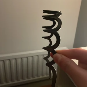 Svart taggigt diadem i plast - Säljer ett svart diadem i plast med taggiga detaljer längs hela bågen. Diademet har en cool och edgy look som sticker ut och håller håret på plats. Perfekt accessoar för dig som vill ha något annorlunda och trendigt i håret.